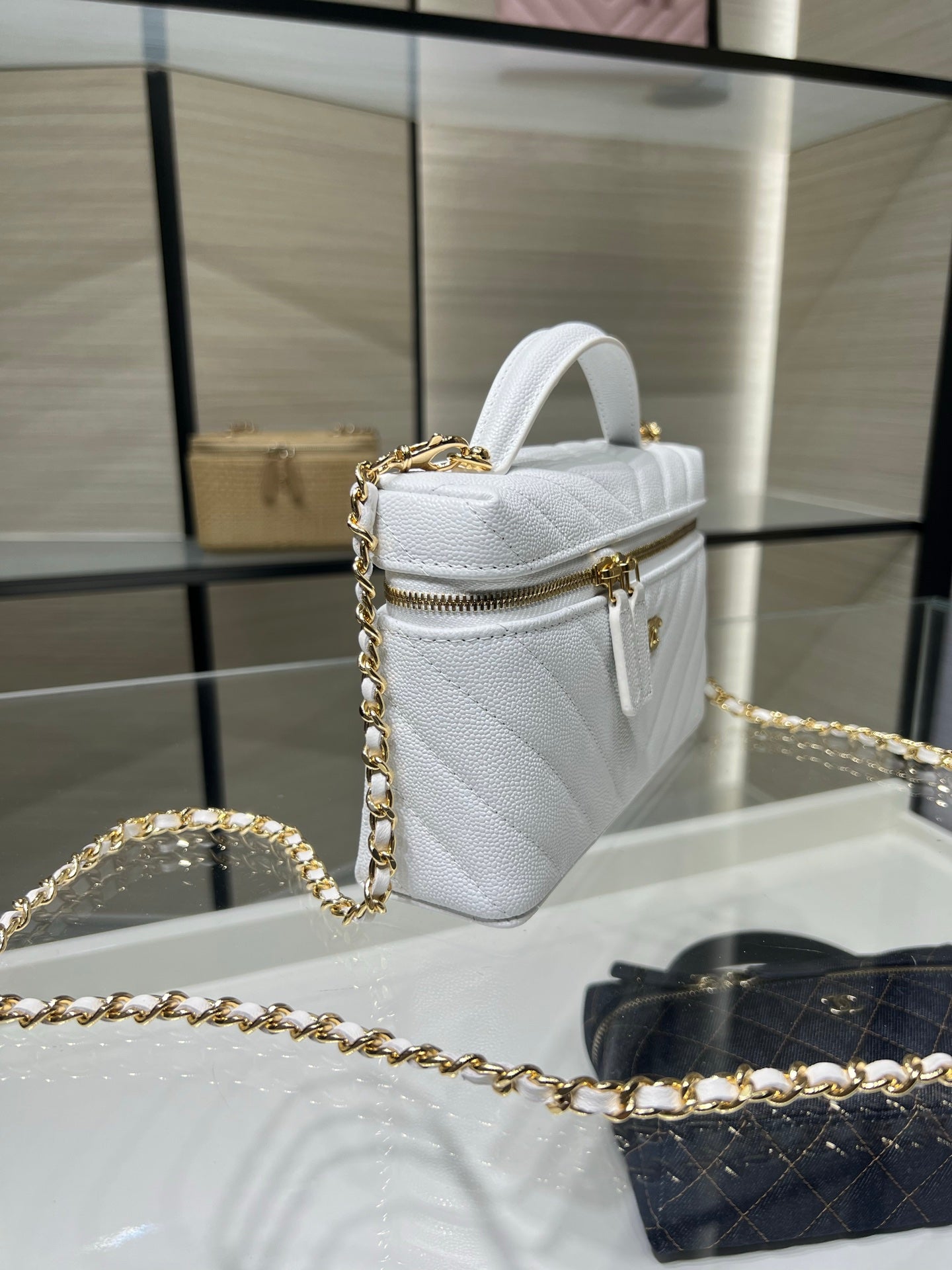 Chanel quilted bag in white with top handle, gold chain strap, and zip closure
