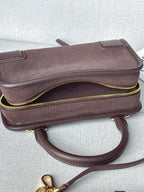 Loewe bag with top zipper and curved strap, textured exterior with gold trim.