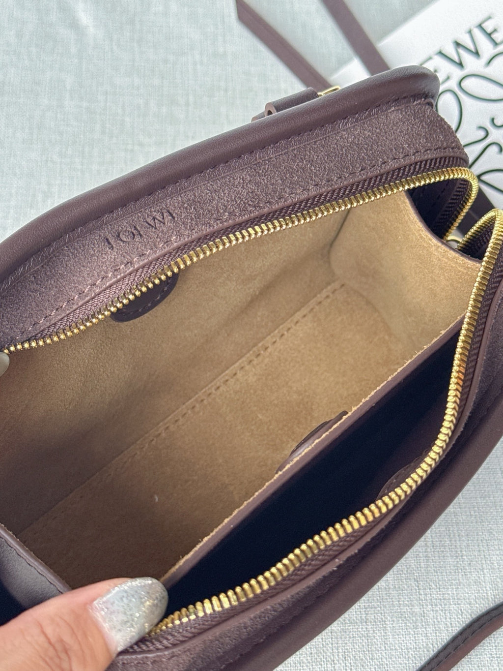 Loewe bag interior view with tan lining and gold zipper edging around the opening.