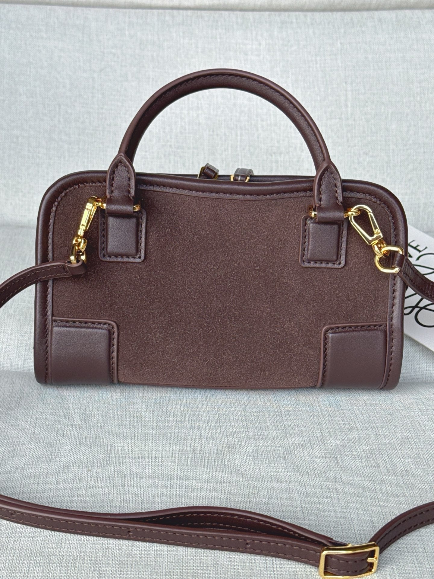 Loewe bag front view with two handles, shoulder strap, and gold buckle details.