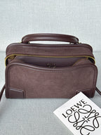 Loewe bag with top handle, adjustable strap, front pocket, and gold zipper trim.