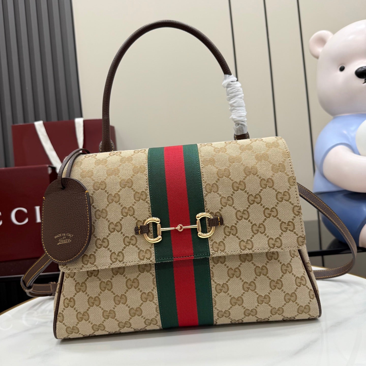 Gucci GG canvas top-handle bag with red and green stripe and gold buckle closure