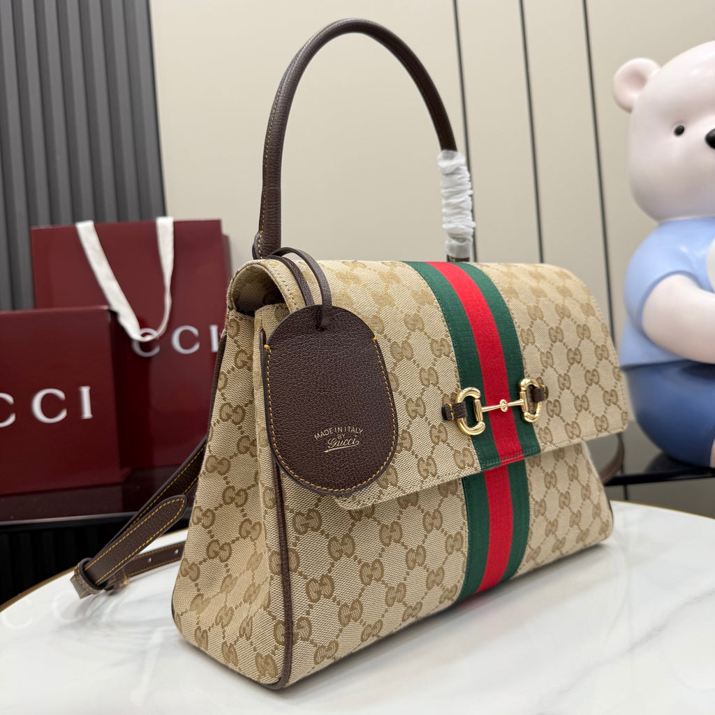 Gucci GG canvas handbag with red and green stripe, leather charm tag, and gold hardware