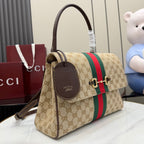 Gucci GG canvas handbag with red and green stripe, leather charm tag, and gold hardware