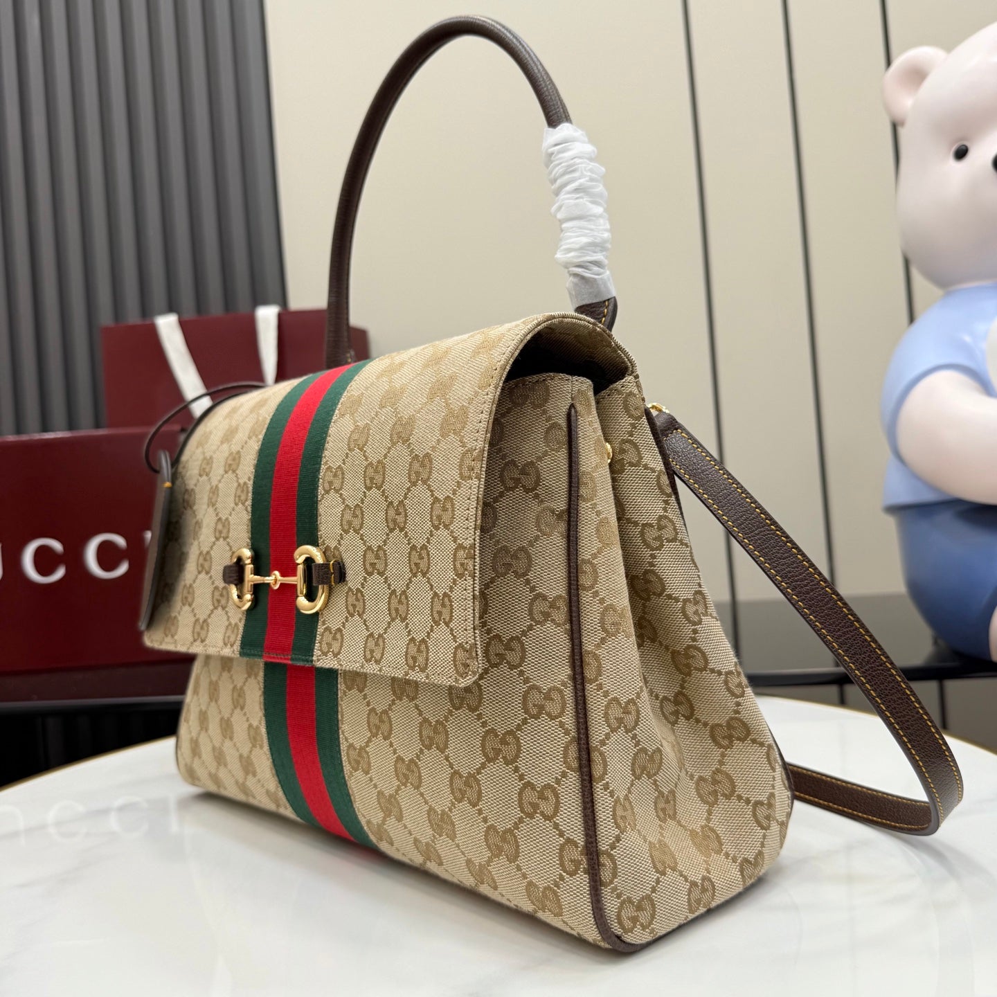 Gucci GG canvas crossbody bag with red and green stripe and brown shoulder strap