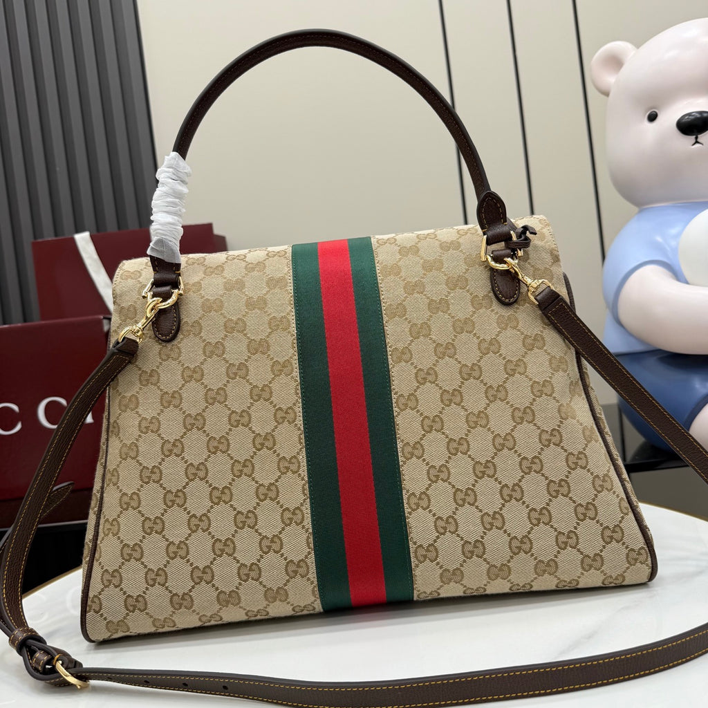 GG-print shoulder bag with long strap, brown leather handles, and green/red web stripe