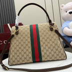 GG-print shoulder bag with long strap, brown leather handles, and green/red web stripe