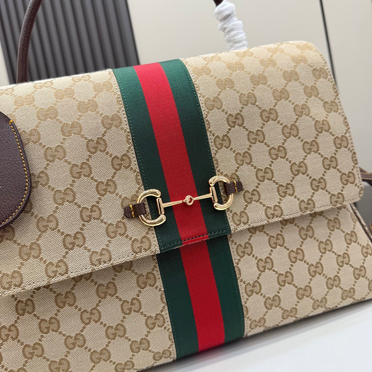 GG-print flap bag close-up with green/red stripe and gold-tone clasp hardware