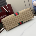 GG-print clutch-style bag with green and red stripe and brown leather trim, angled view