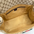 Interior of GG-print bag with beige lining and zippered pocket, open top view