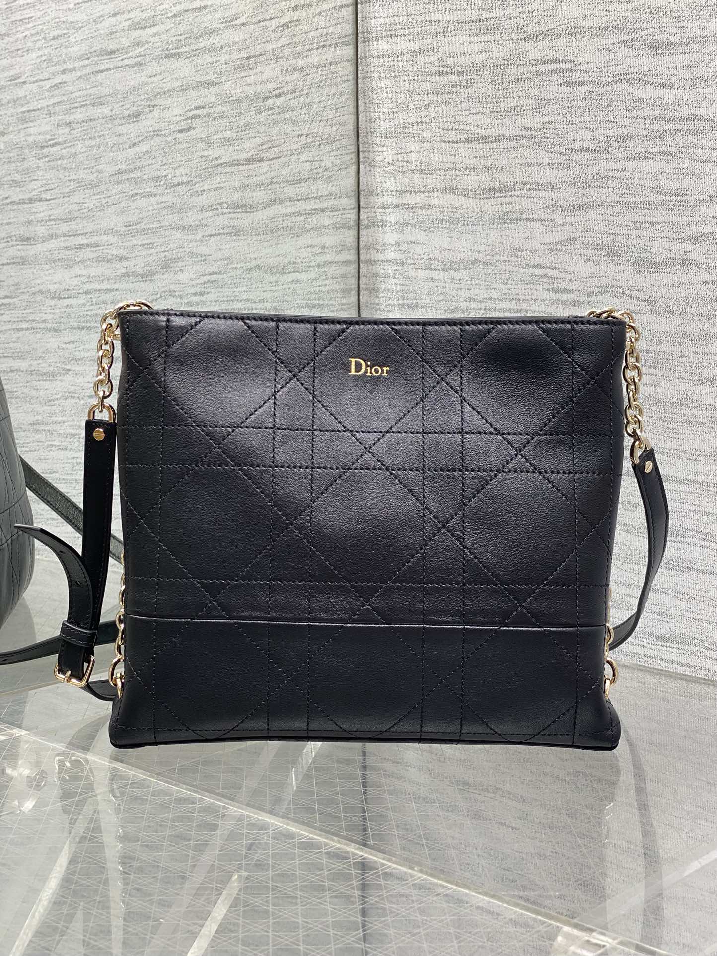 Dior quilted leather crossbody bag with chain strap and flap front, dark navy.