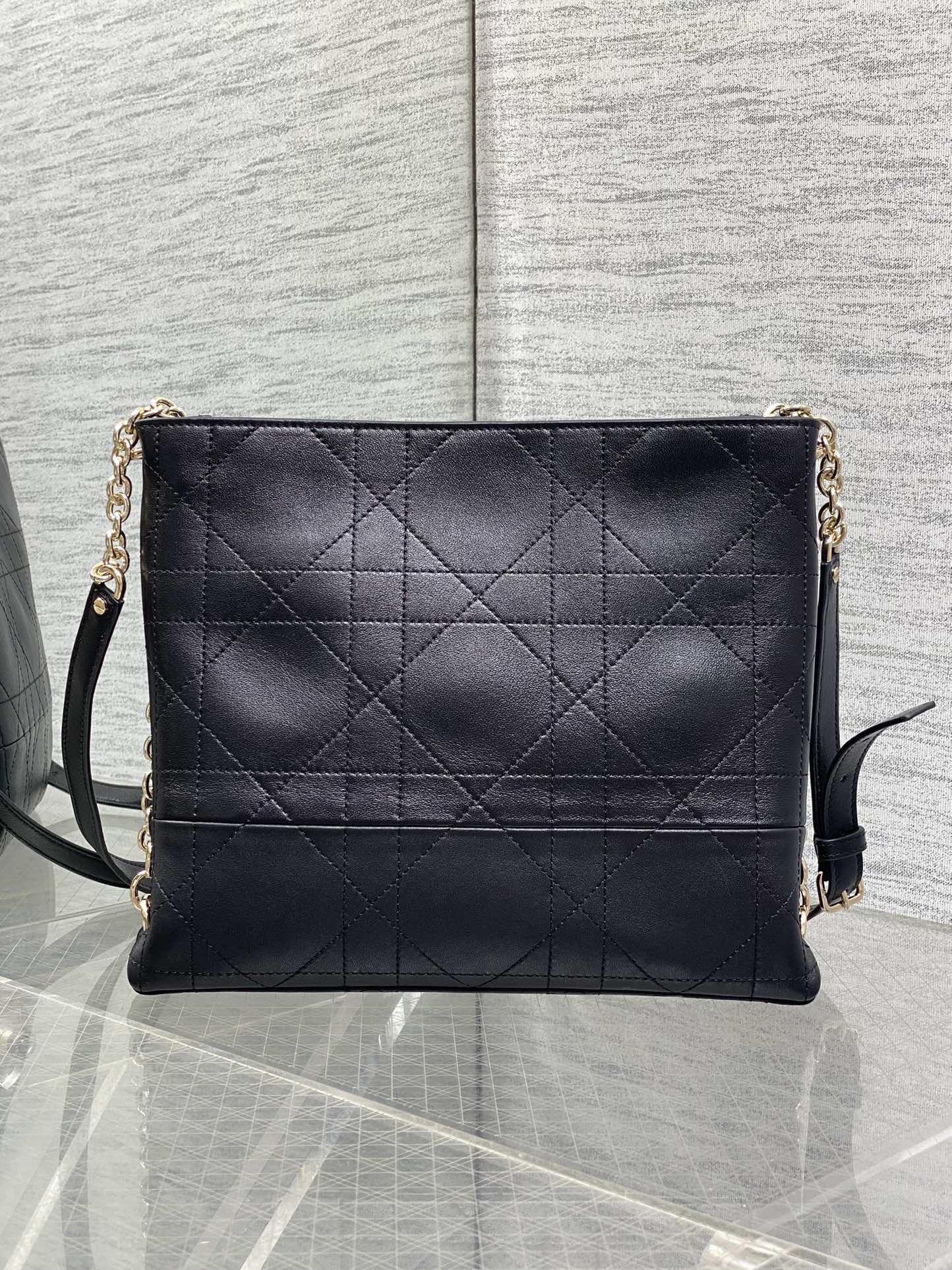 Dior quilted leather shoulder bag with chain strap and flap front, dark navy.