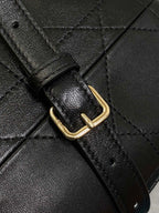 Dior leather bag strap with gold-tone buckle and quilted leather panel, dark.