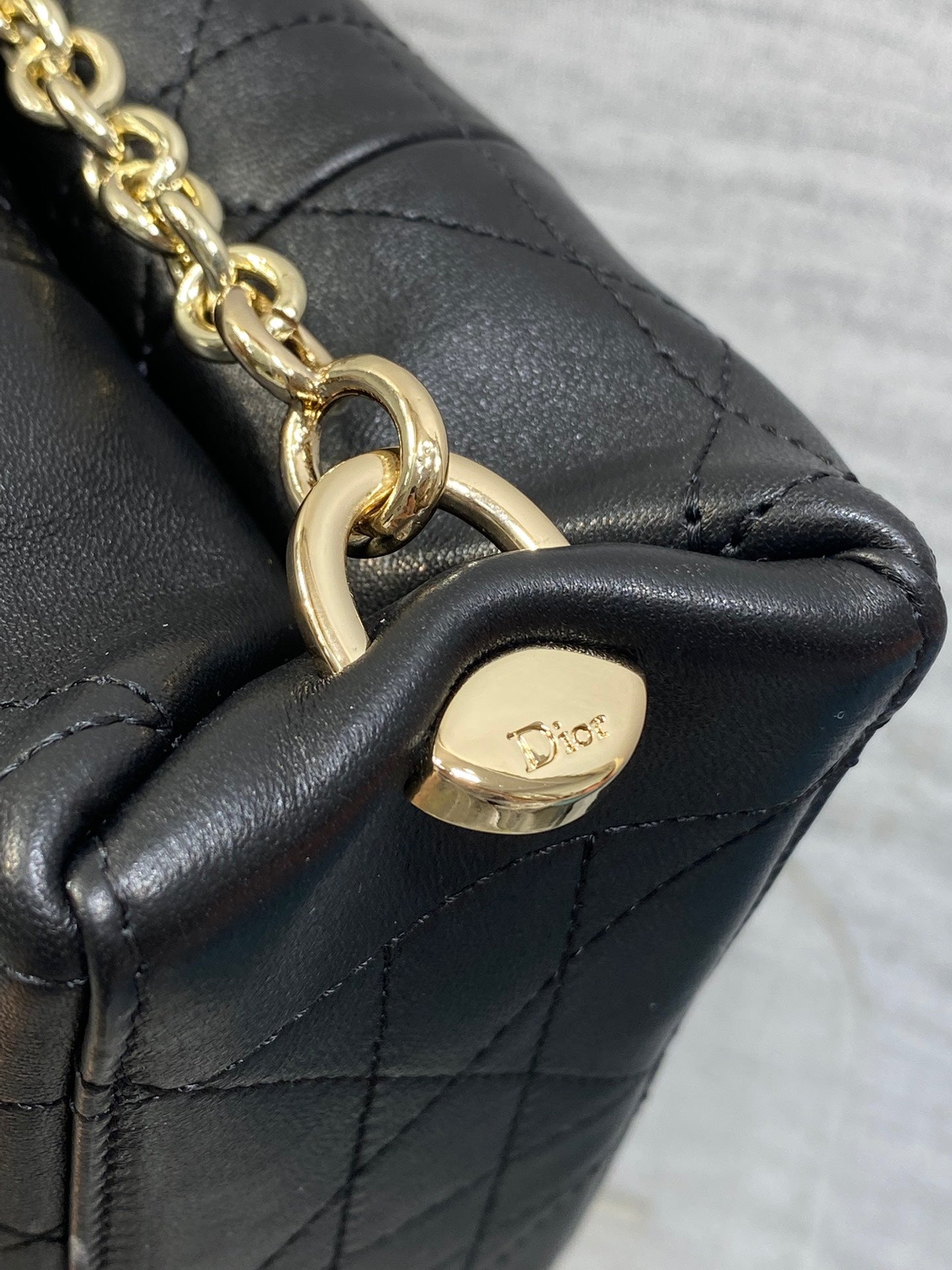 Dior chain shoulder bag end with gold-tone links and small logo plaque.