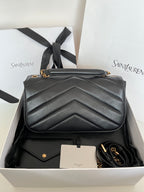 Dark gray leather YSL bag with chevron quilting, gold emblem, and short shoulder strap.