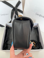 Dark gray leather YSL mini bag with rounded top handle and gold hardware.
