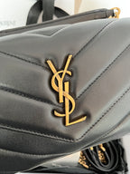 Dark gray leather flap with gold YSL logo detail and stitched chevron panel.
