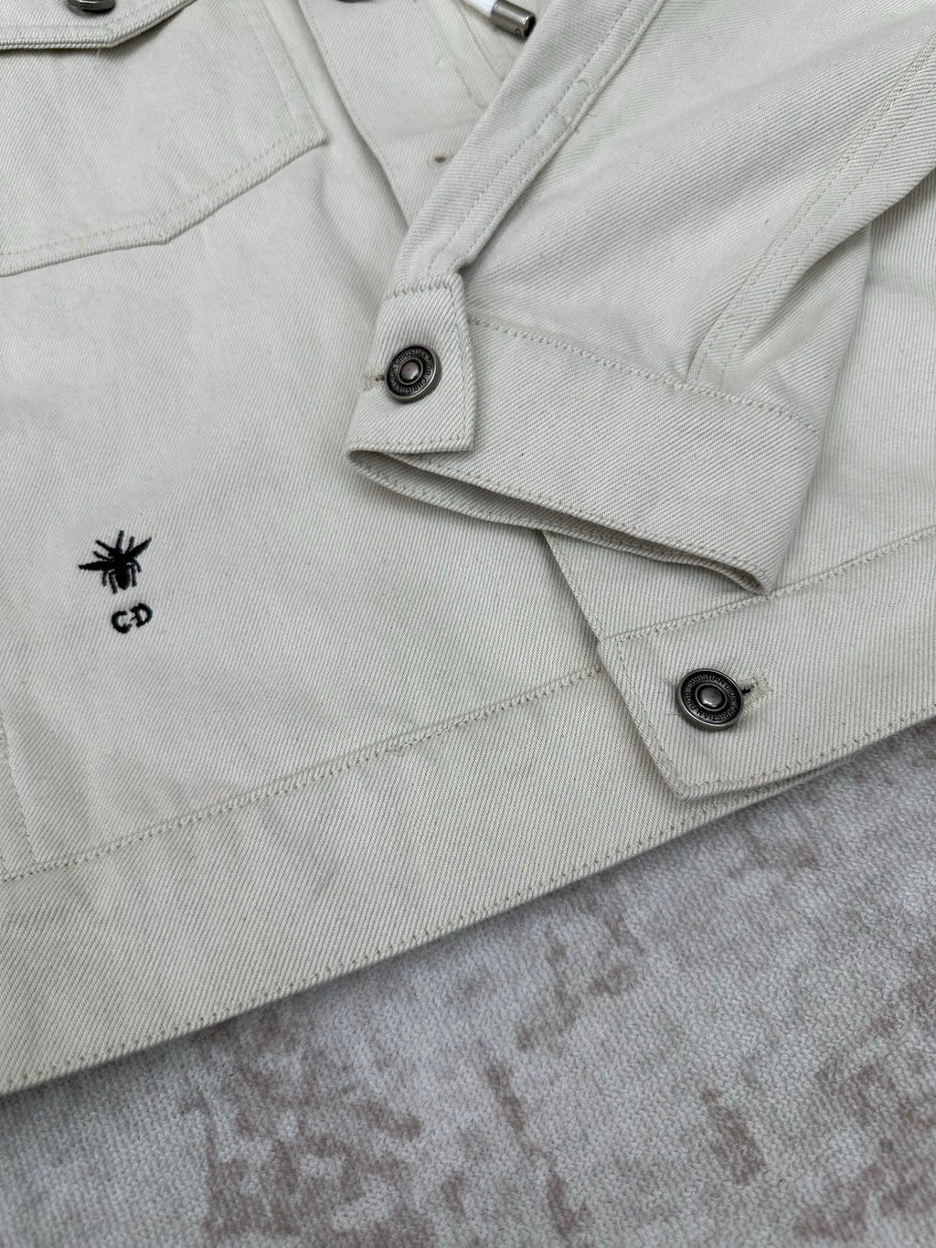 White jacket with CD logo patch on pocket flap and snap button