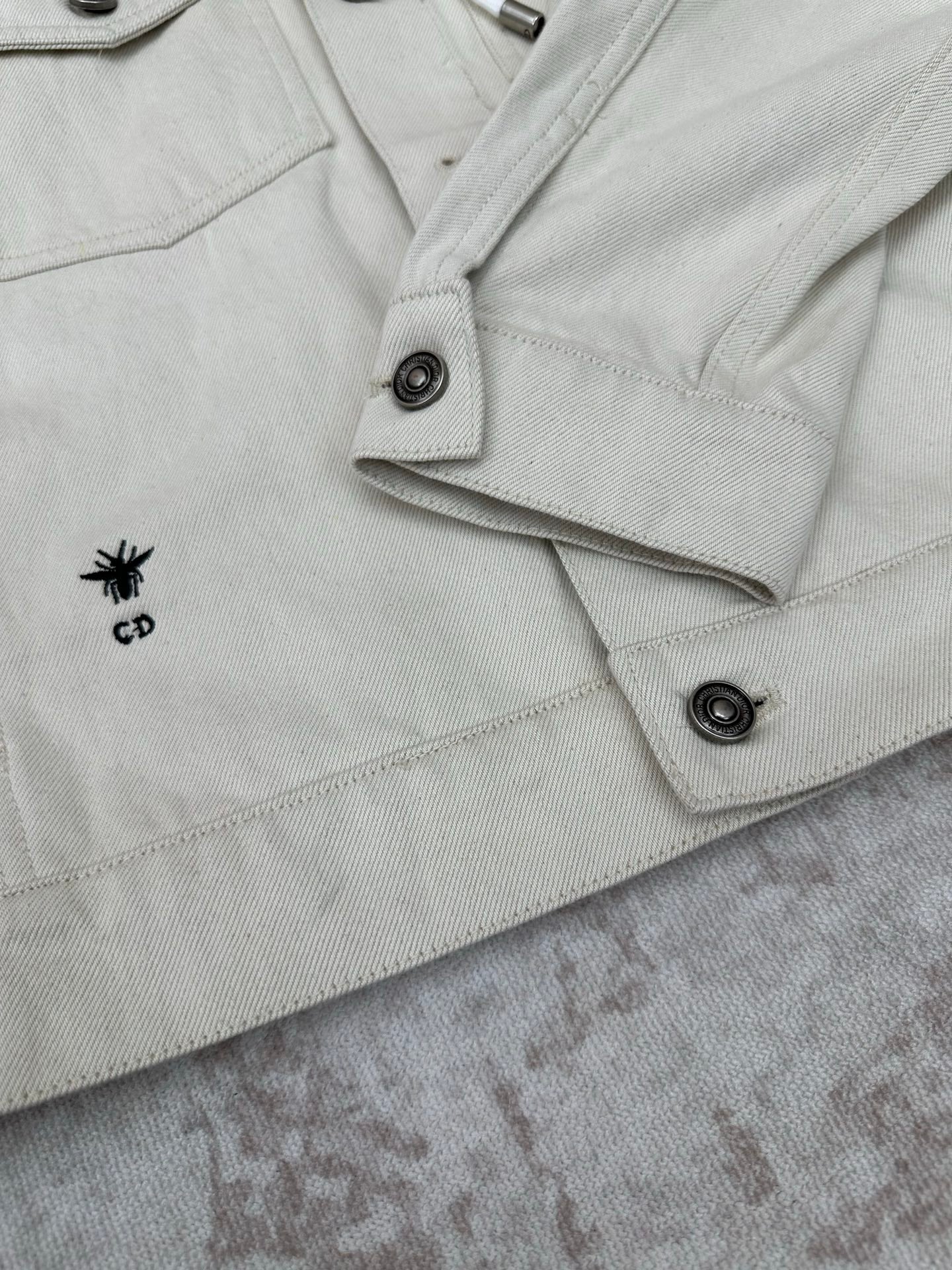 White jacket with CD logo patch on pocket flap and snap button