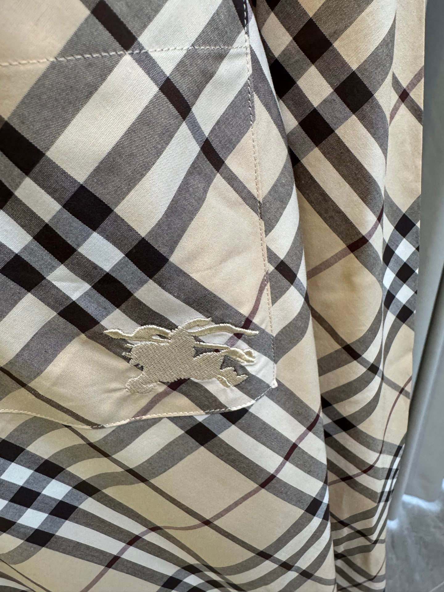 Burberry plaid shirt fabric close-up with embroidered chest patch