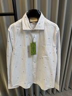 Long-sleeve light striped shirt with blue dot motifs, chest pocket, and green tag