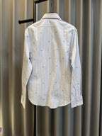 Back view of a long-sleeve button shirt in light stripes with blue dot motifs