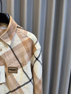 Burberry check shirt close-up, beige fabric with navy plaid lines and chest logo patch