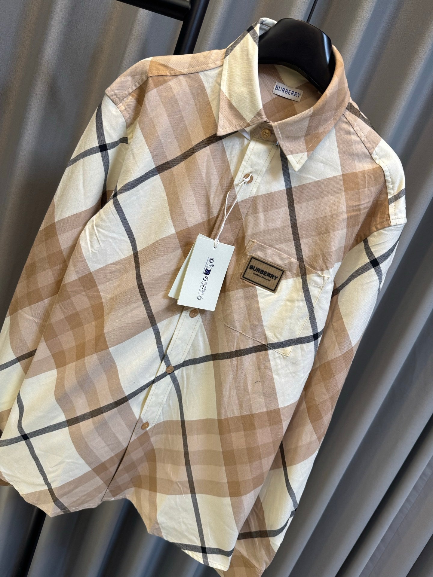 Burberry long-sleeve check shirt, beige with navy plaid lines, front close-up on hanger