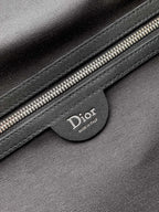 Dior bag close-up of black leather patch with Dior logo and silver zipper