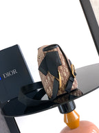 Dior crossbody bag, beige pattern with black strap and flap, gold-tone hardware