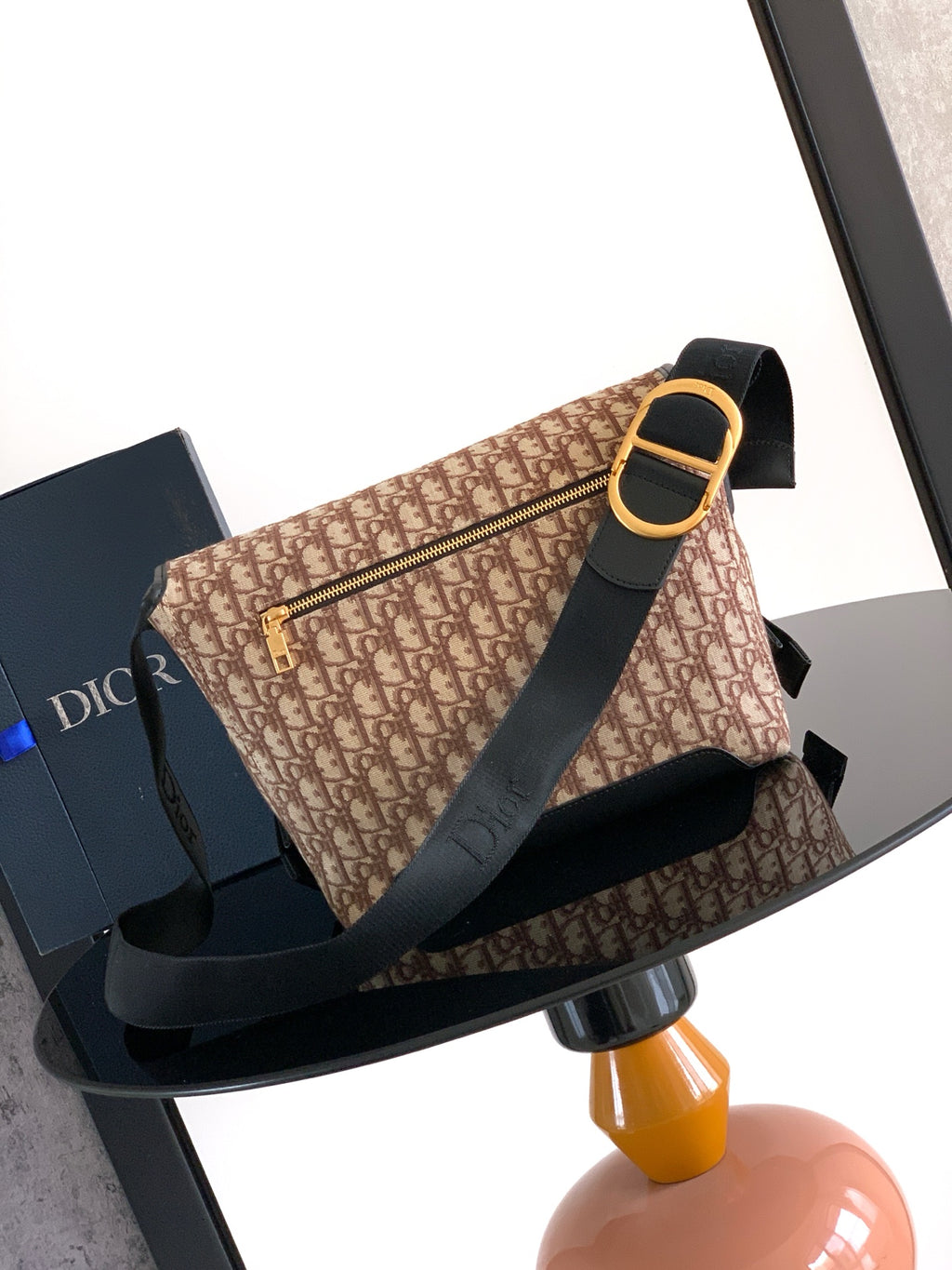 Dior shoulder bag, beige monogram pattern with black strap and gold-tone buckle
