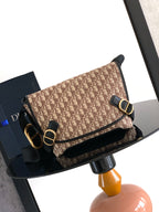 Dior shoulder bag, beige patterned with black trim, gold-tone buckle and strap