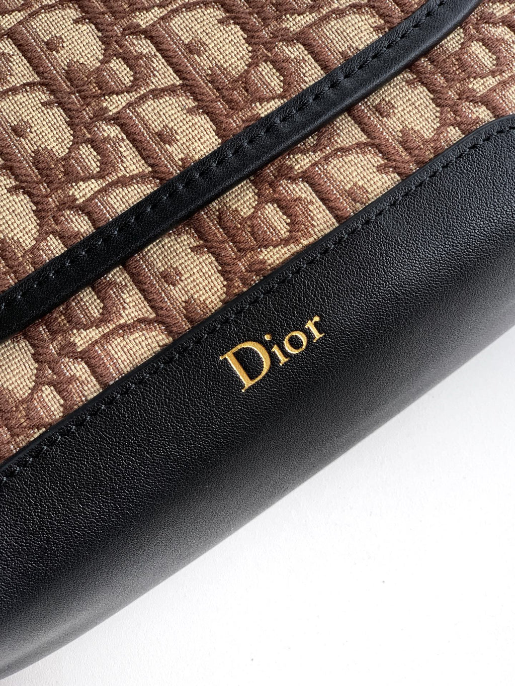 Dior monogram canvas with black leather panel and gold Dior logo