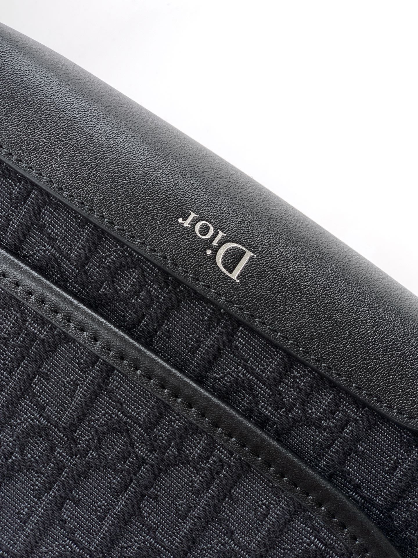 Dior logo detail on textured leather edge, dark