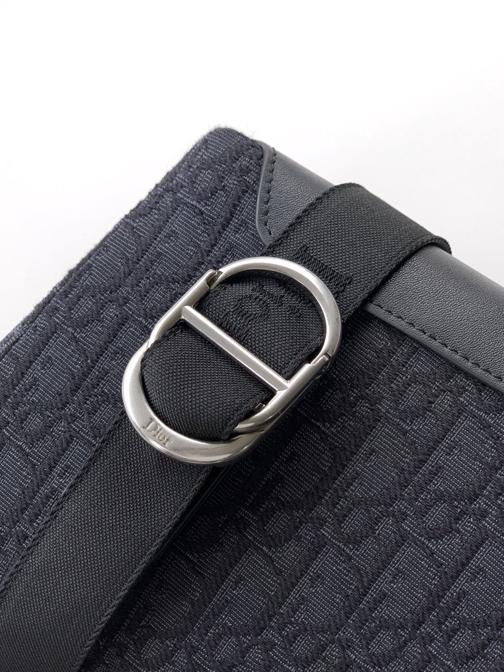 Dior monogram bag with silver D-ring buckle on shoulder strap, dark