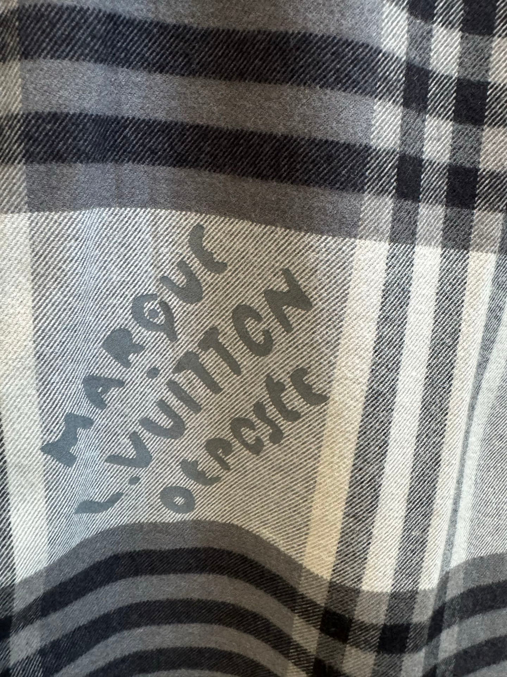 Louis Vuitton plaid fabric close-up with printed logo design
