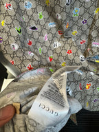 Gucci short-sleeve shirt fabric close-up with multicolor cartoon logo icons