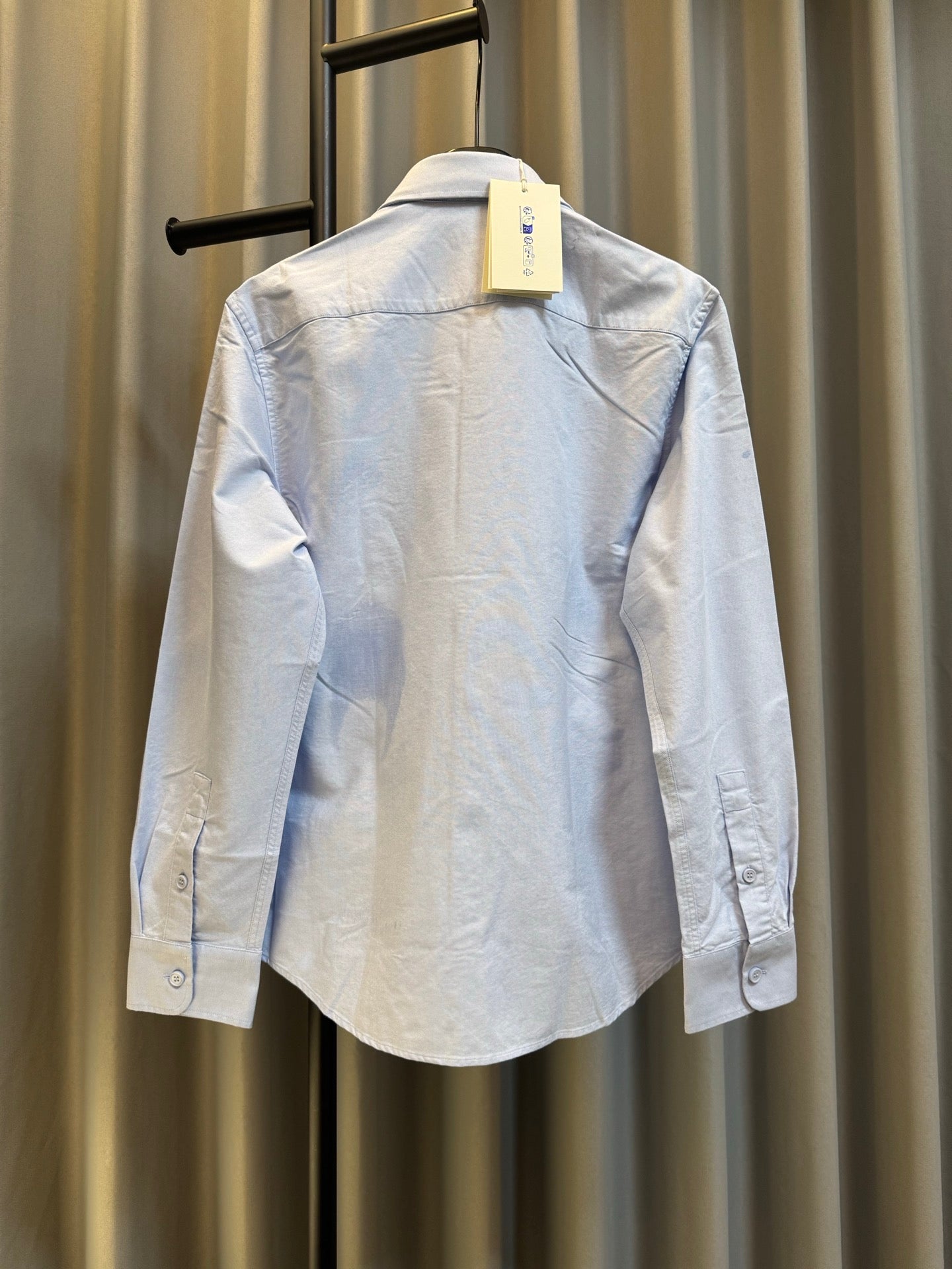 Light blue Burberry button-up shirt from back view with tag at neck