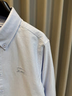 Light blue Burberry button-up shirt sleeve with small embroidered horse logo