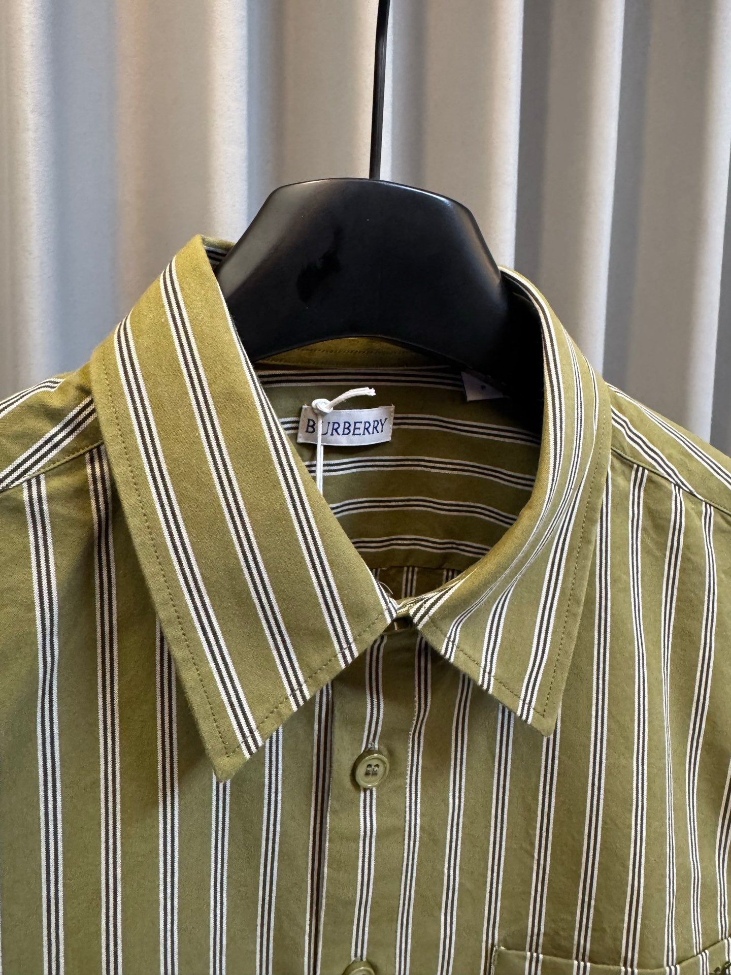 Green striped button-up shirt with point collar and button detail