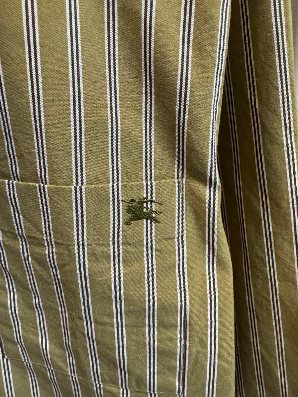 Green and white striped shirt sleeve with stitched cuff detail