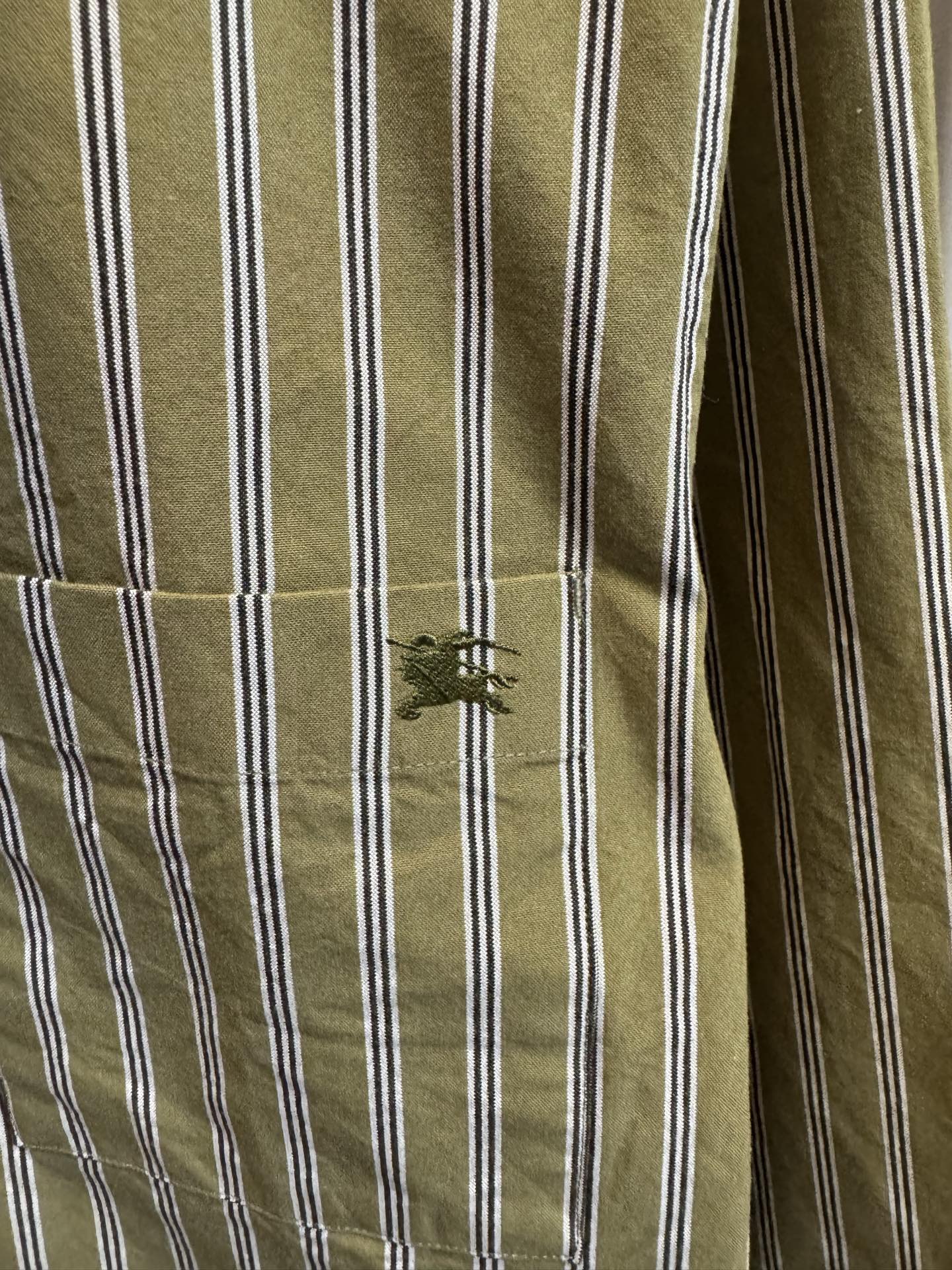 Green and white striped shirt sleeve with stitched cuff detail