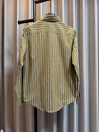 Back view of green striped button-up shirt on hanger