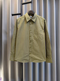 Green striped button-up shirt with point collar on hanger