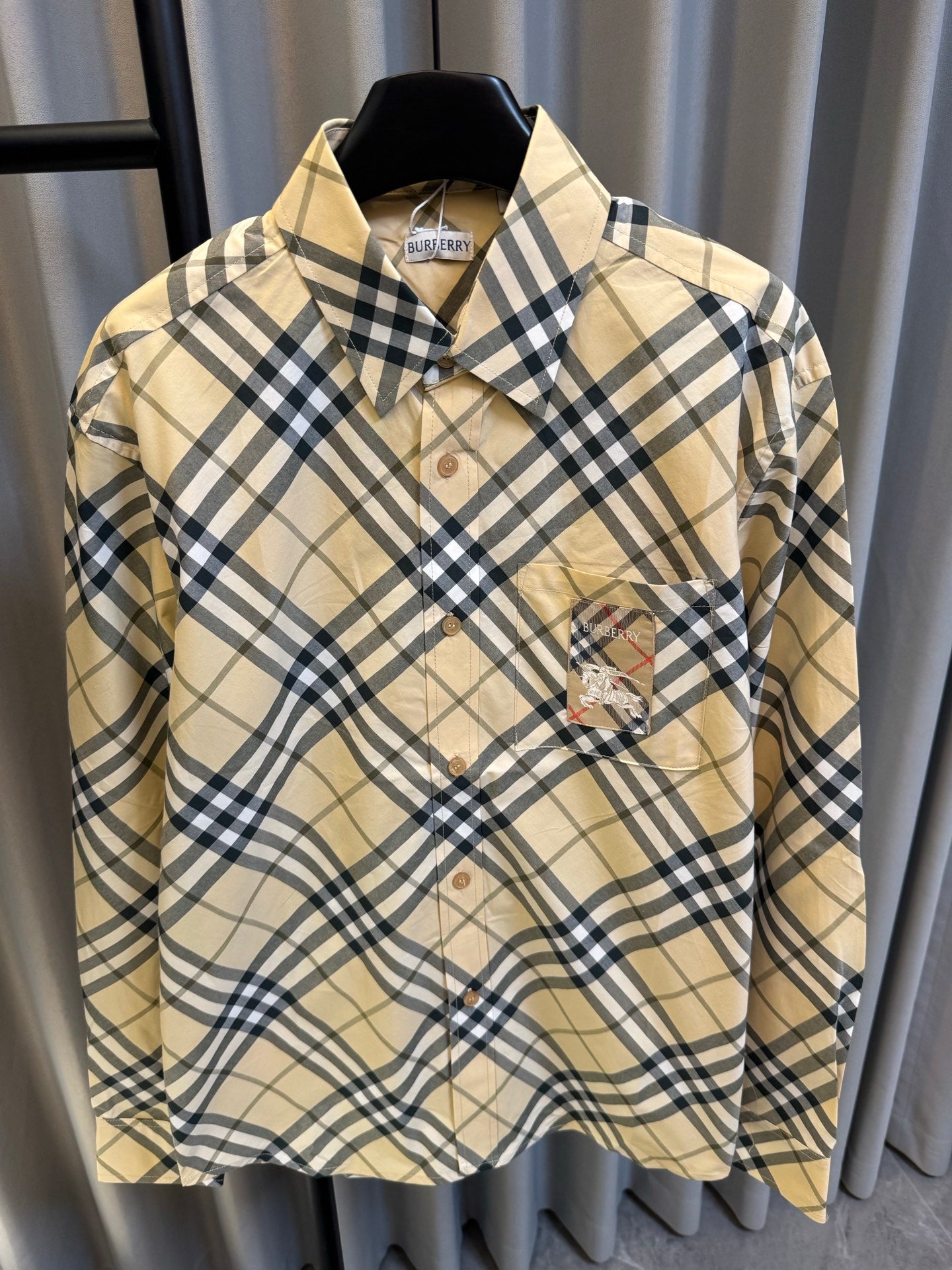 Burberry tan plaid button-up shirt with navy checks, button placket, and embroidered chest patch