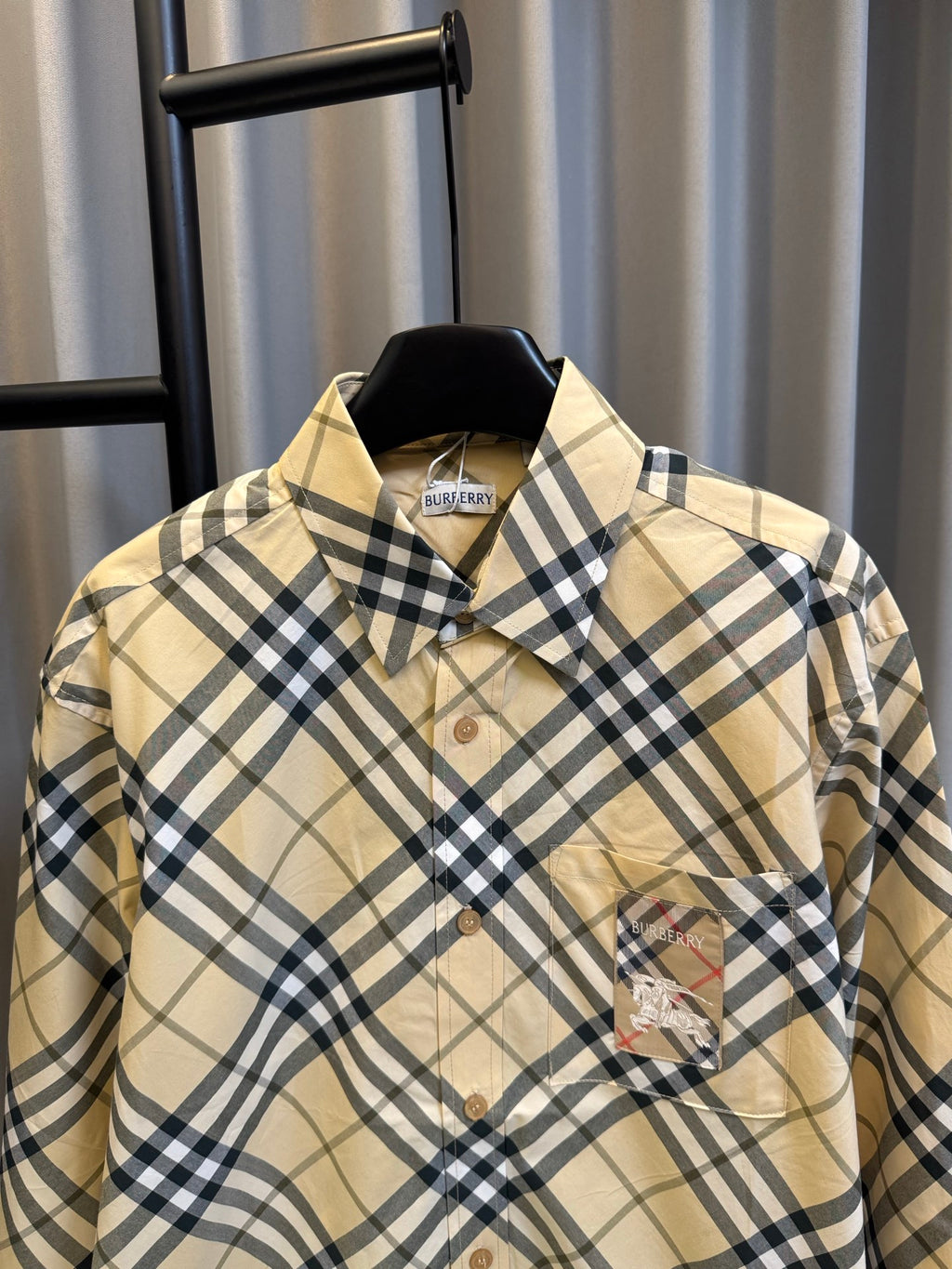 Burberry plaid button-up shirt in tan and navy checks with collar and chest logo patch