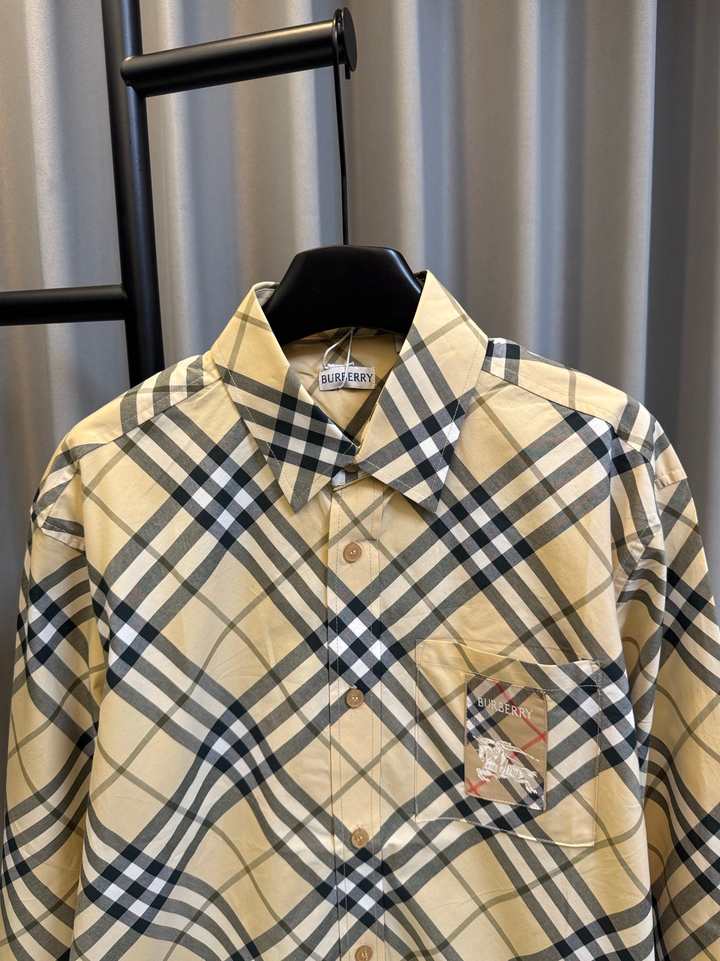 Burberry plaid button-up shirt in tan and navy checks with collar and chest logo patch