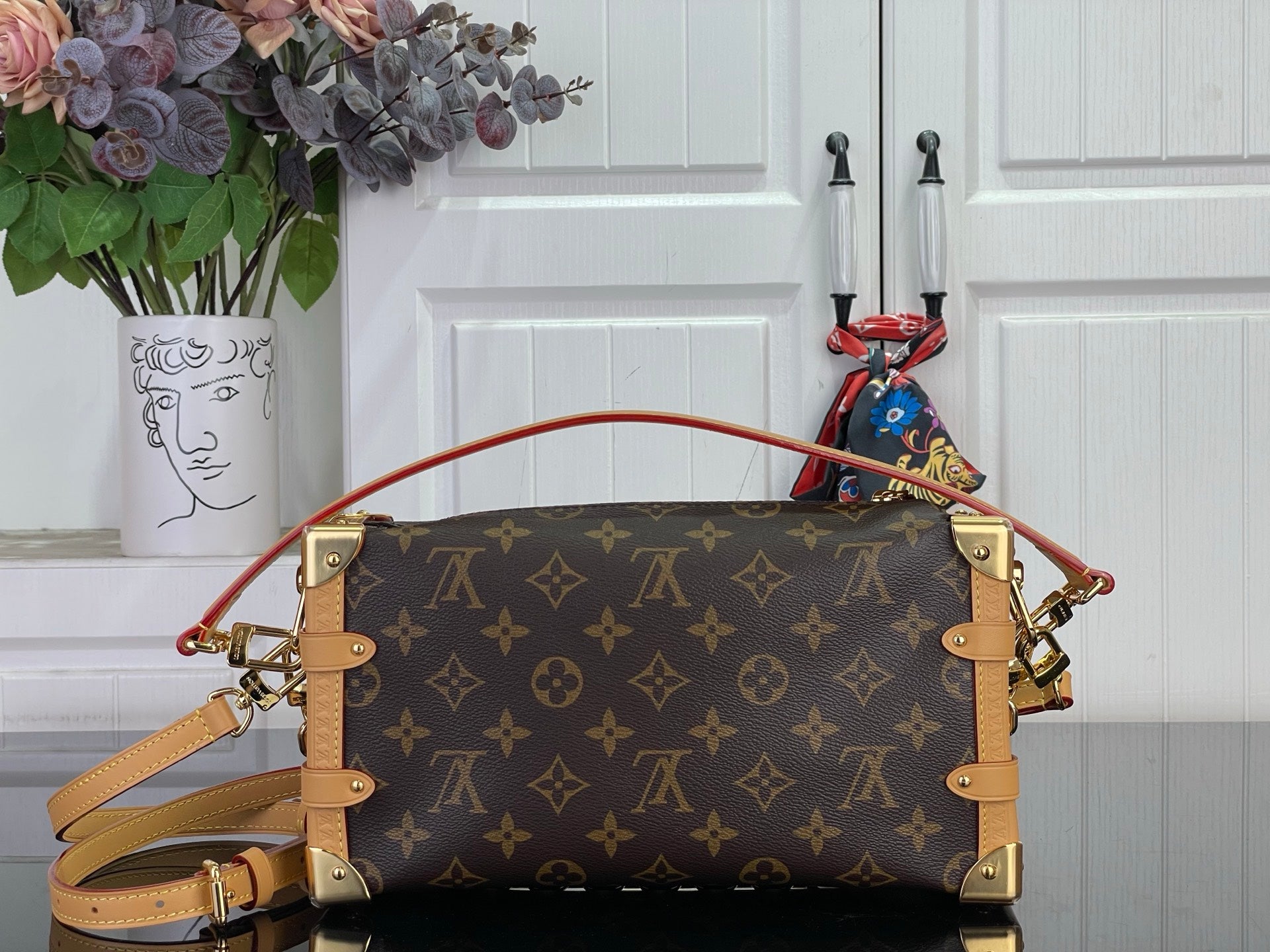 Louis Vuitton monogram handbag with tan leather handles and gold chain strap
