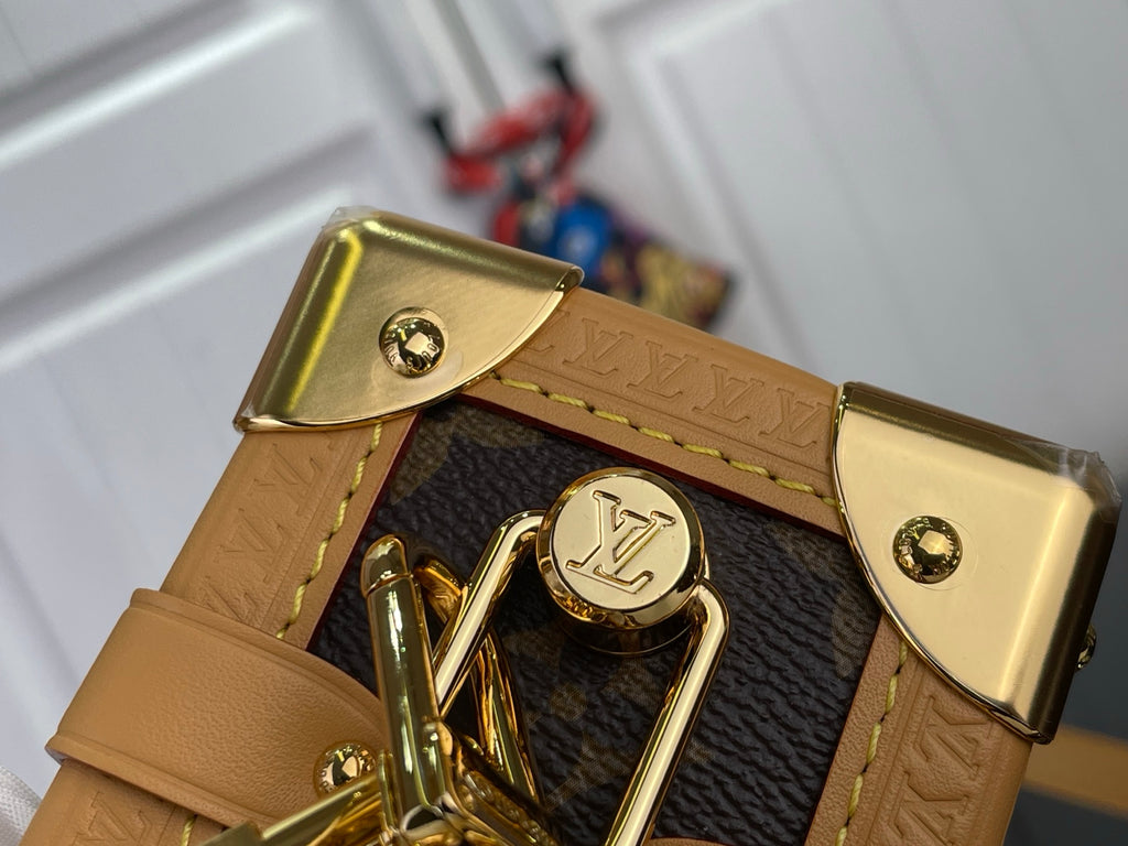 Louis Vuitton monogram bag close-up of tan leather tab and gold clasp
