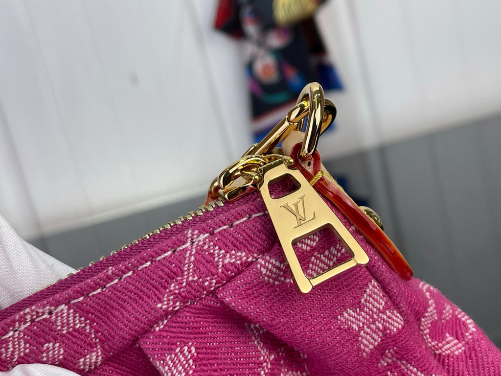 Louis Vuitton gold-tone clasp and chain link hardware on pink monogram fabric.